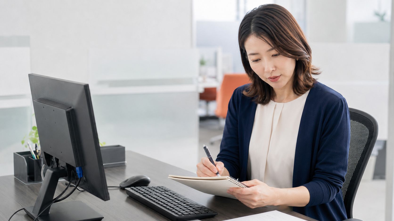 業務推進・会計事務スタッフが資料と進捗を一人で確認する様子